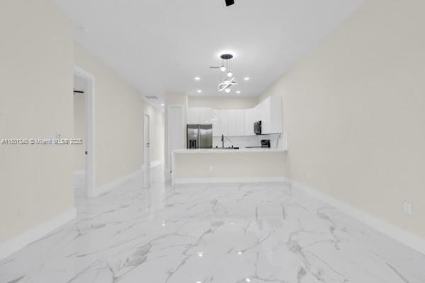 428/430 Petite Ave, Lehigh Acres, FL 33974 - unfurnished living room with baseboards, light marble finish floors, a chandelier, and recessed lighting