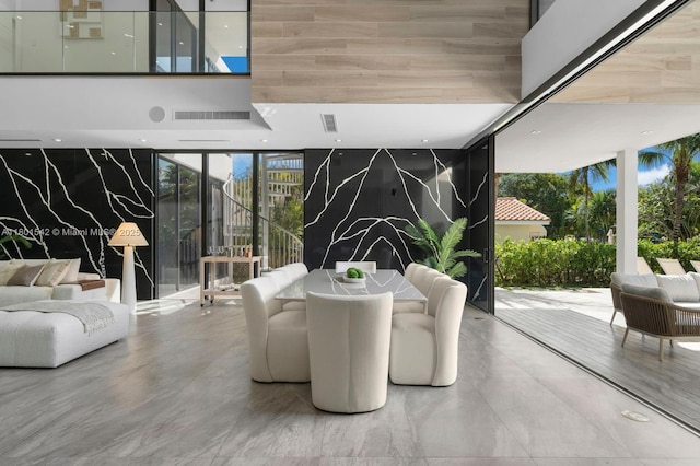 521 Holiday Dr, Hallandale Beach, FL 33009 - dining room featuring a wall of windows, marble finish flooring, and a towering ceiling
