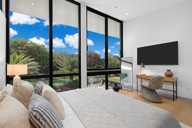 521 Holiday Dr, Hallandale Beach, FL 33009 - bedroom featuring a wall of windows and wood finished floors