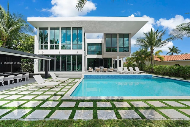 521 Holiday Dr, Hallandale Beach, FL 33009 - rear view of house featuring a patio and an outdoor pool