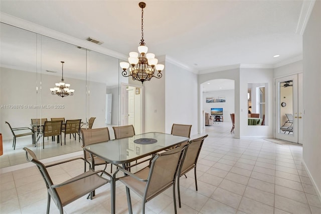 dining area with a chandelier, ornamental molding, light tile patterned flooring, arched walkways, and baseboards