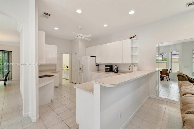 kitchen with white fridge with ice dispenser, a peninsula, open shelves, light countertops, and a ceiling fan