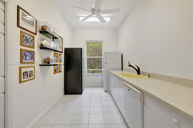 laundry room with a sink, a ceiling fan, light tile patterned floors, and baseboards