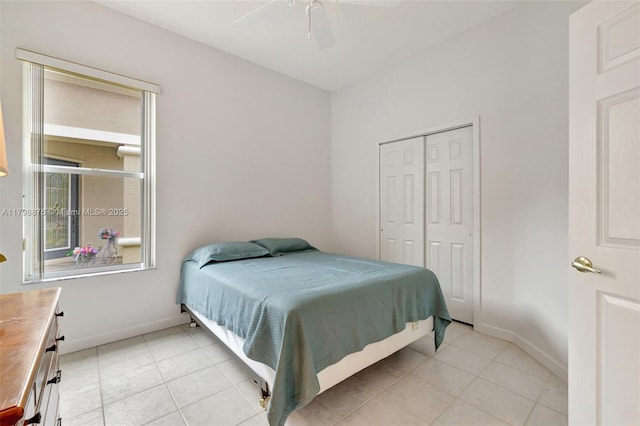 bedroom featuring light tile patterned floors, a closet, and baseboards