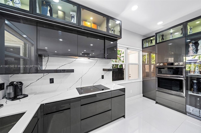 1496 Breakwater Ter, Hollywood, FL 33019 - kitchen featuring black electric stovetop, modern cabinets, light tile patterned floors, light stone countertops, and recessed lighting