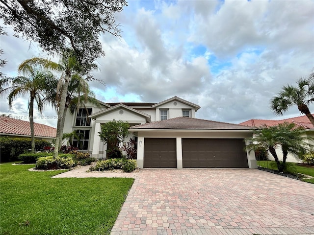 3968 Nighthawk Dr, Weston, FL 33331 - view of front facade featuring decorative driveway, an attached garage, a front yard, stucco siding, and a tile roof