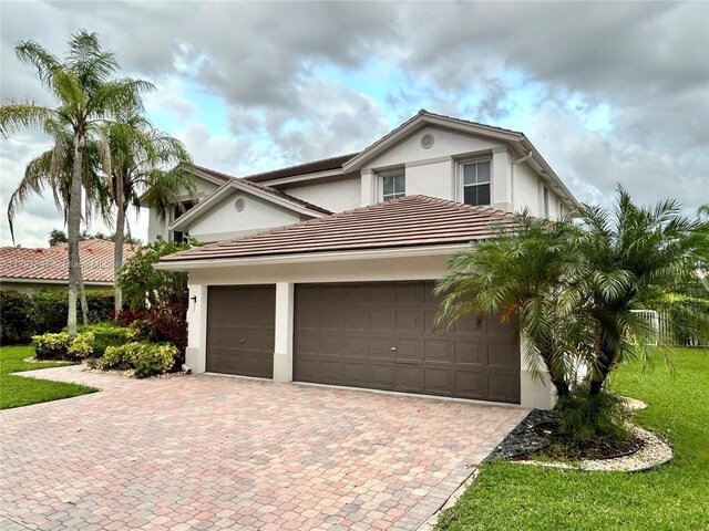 3968 Nighthawk Dr, Weston, FL 33331 - view of front facade featuring stucco siding, decorative driveway, an attached garage, and a front lawn
