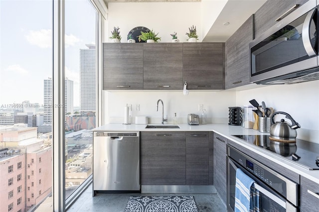 151 SE 1st St Unit 1610, Miami, FL 33131 - kitchen featuring appliances with stainless steel finishes, a sink, modern cabinets, light countertops, and expansive windows