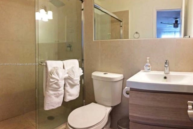 314 SE 4th St, Dania Beach, FL 33004 - bathroom featuring a stall shower, toilet, vanity, and tile walls