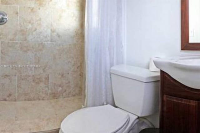 314 SE 4th St, Dania Beach, FL 33004 - bathroom with toilet, a tile shower, and vanity
