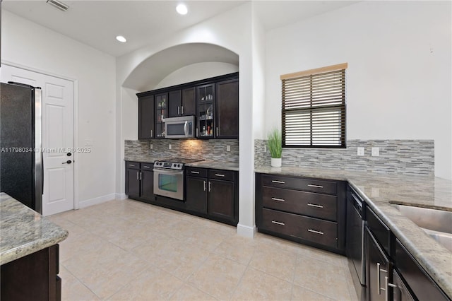 2691 NW 83rd Ter, Cooper City, FL 33024 - kitchen featuring appliances with stainless steel finishes, light tile patterned flooring, decorative backsplash, light stone counters, and recessed lighting