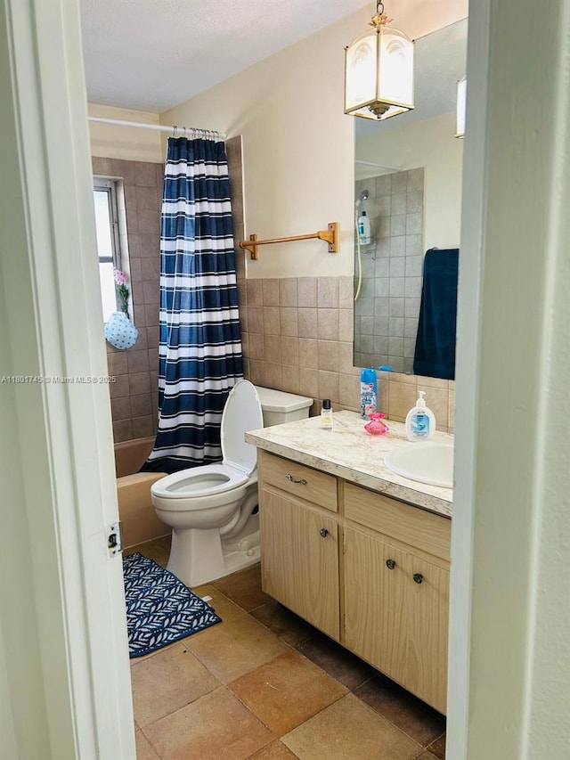 full bath featuring tile walls, toilet, vanity, and shower / bath combo with shower curtain