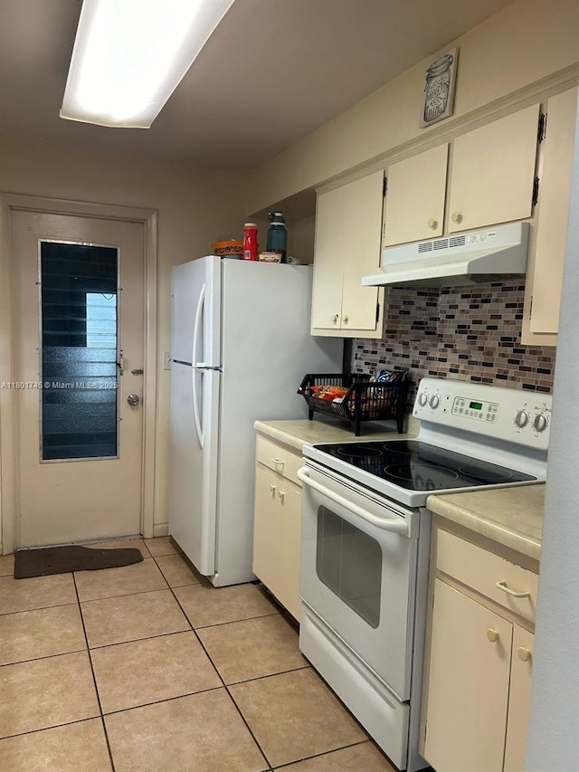 kitchen with under cabinet range hood, white range with electric cooktop, light countertops, light tile patterned floors, and decorative backsplash
