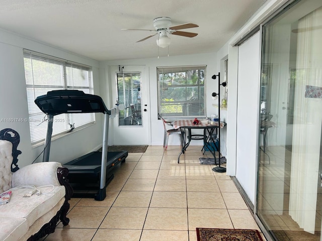 workout room featuring ceiling fan and light tile patterned floors