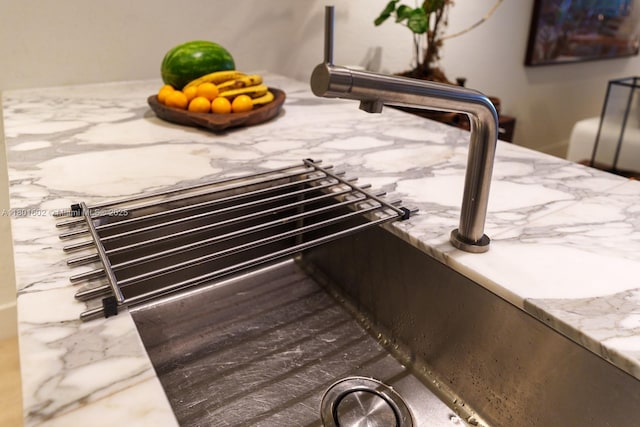 detailed view of light stone counters and a sink