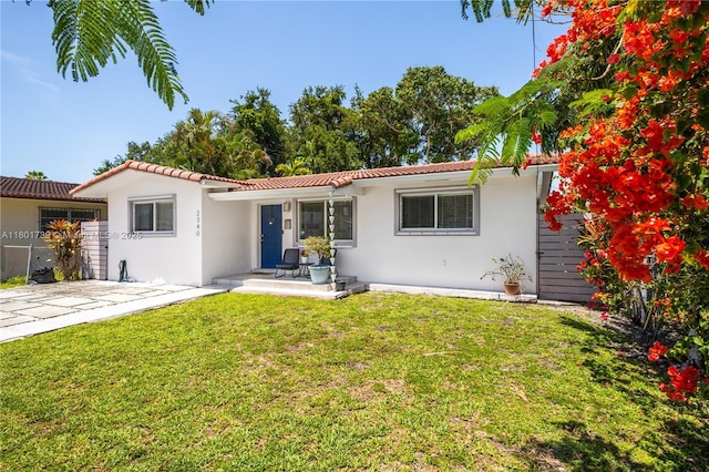 2340 SW 17th Ave, Miami, FL 33145 - view of front of house with stucco siding, a tiled roof, a front lawn, and a porch