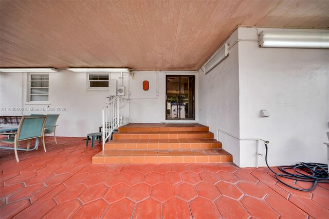 view of exterior entry featuring stucco siding and a patio