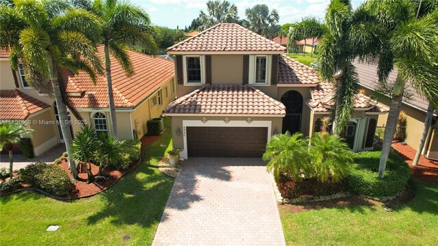 4940 Gateway Gardens Dr, Boynton Beach, FL 33436 - mediterranean / spanish-style house with stucco siding, an attached garage, a tiled roof, decorative driveway, and a front yard