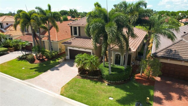 4940 Gateway Gardens Dr, Boynton Beach, FL 33436 - mediterranean / spanish-style house featuring stucco siding, decorative driveway, a tile roof, and a front yard