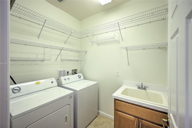 4940 Gateway Gardens Dr, Boynton Beach, FL 33436 - laundry room with washer and clothes dryer, cabinet space, light tile patterned flooring, and baseboards