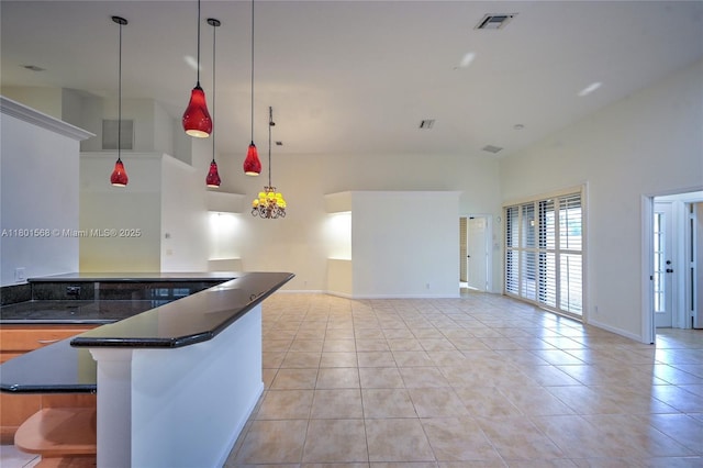 4940 Gateway Gardens Dr, Boynton Beach, FL 33436 - kitchen featuring dark countertops, light tile patterned floors, a high ceiling, hanging light fixtures, and baseboards