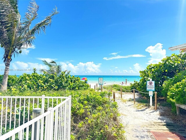 water view featuring nearby beach and fence