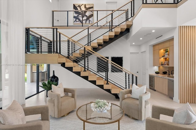 living room with a high ceiling, wine cooler, stairway, and recessed lighting