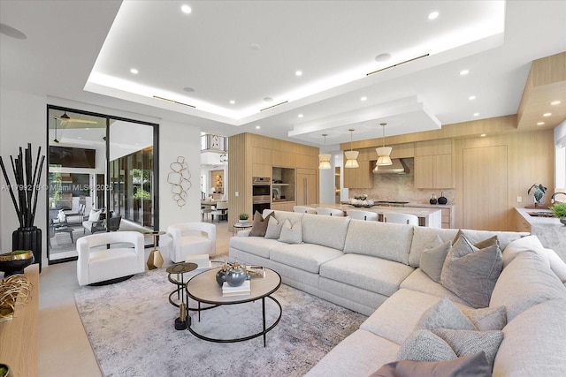 living room with a tray ceiling and recessed lighting