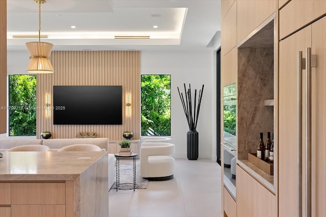 living area featuring a raised ceiling and recessed lighting