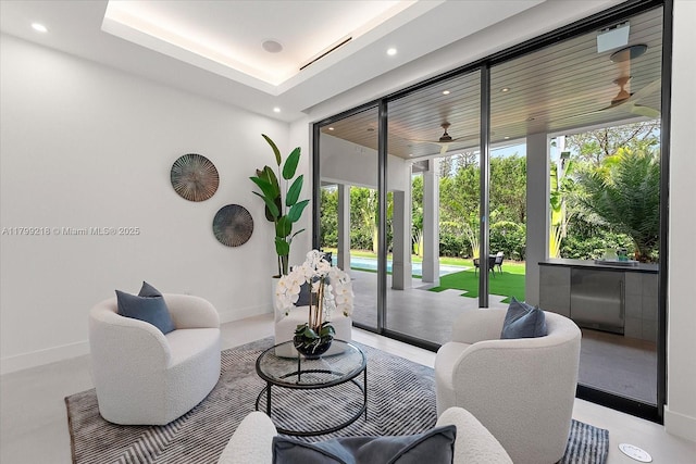 living room featuring baseboards, recessed lighting, and expansive windows