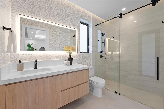 bathroom featuring a stall shower, wallpapered walls, toilet, vanity, and tile patterned floors
