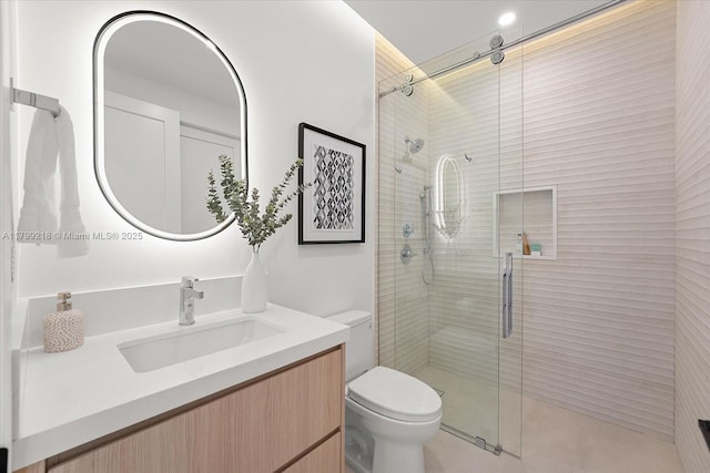 full bath featuring a stall shower, toilet, and vanity