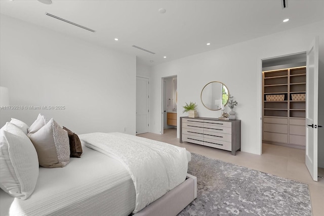 bedroom with a walk in closet, recessed lighting, and a closet