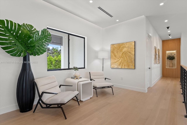 sitting room with baseboards, light wood-style flooring, and recessed lighting