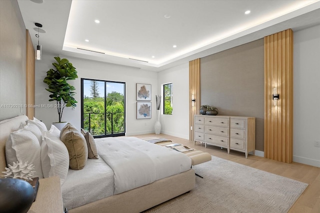 bedroom with recessed lighting, baseboards, a raised ceiling, and light wood-style flooring
