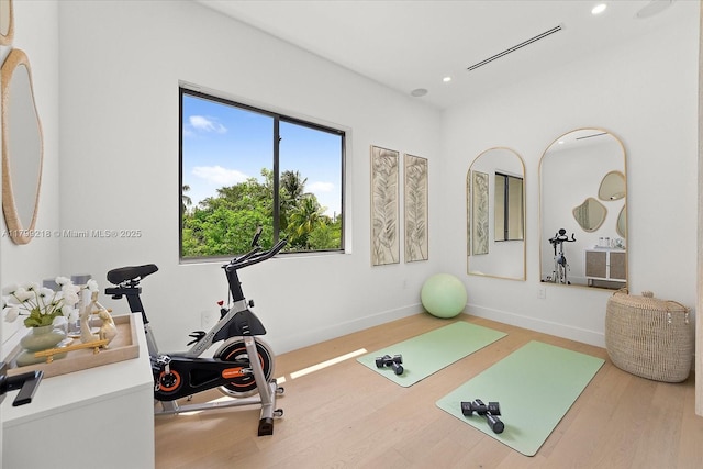 workout area with wood finished floors, recessed lighting, and baseboards