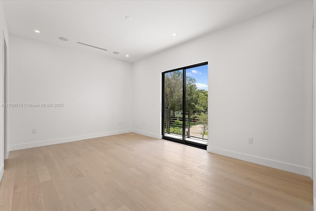 spare room with light wood-type flooring, baseboards, and recessed lighting