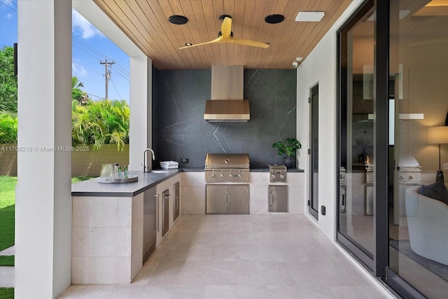 view of patio / terrace featuring exterior kitchen, a sink, a ceiling fan, and a grill