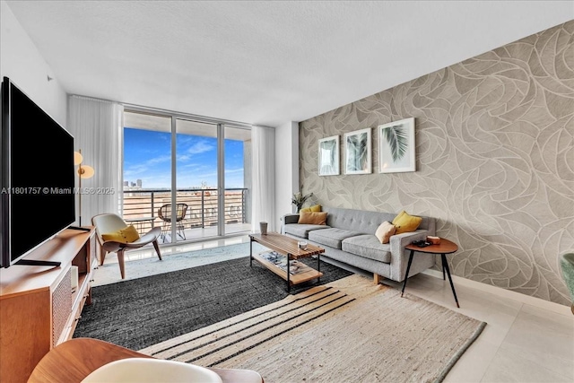 living area with wallpapered walls, floor to ceiling windows, an accent wall, and plenty of natural light