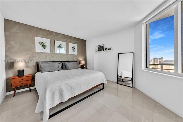 bedroom with an accent wall and baseboards