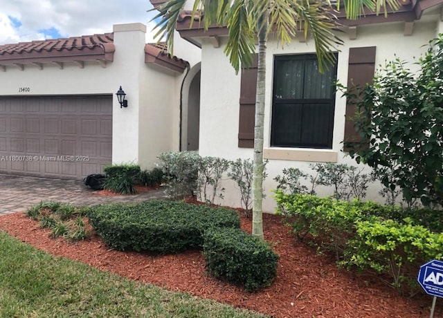 15400 SW 176th Ln, Miami, FL 33187 - view of property exterior with stucco siding, a tile roof, and an attached garage
