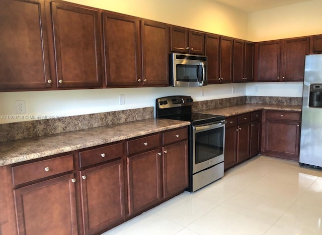 15400 SW 176th Ln, Miami, FL 33187 - kitchen featuring stainless steel appliances, light tile patterned flooring, and dark countertops