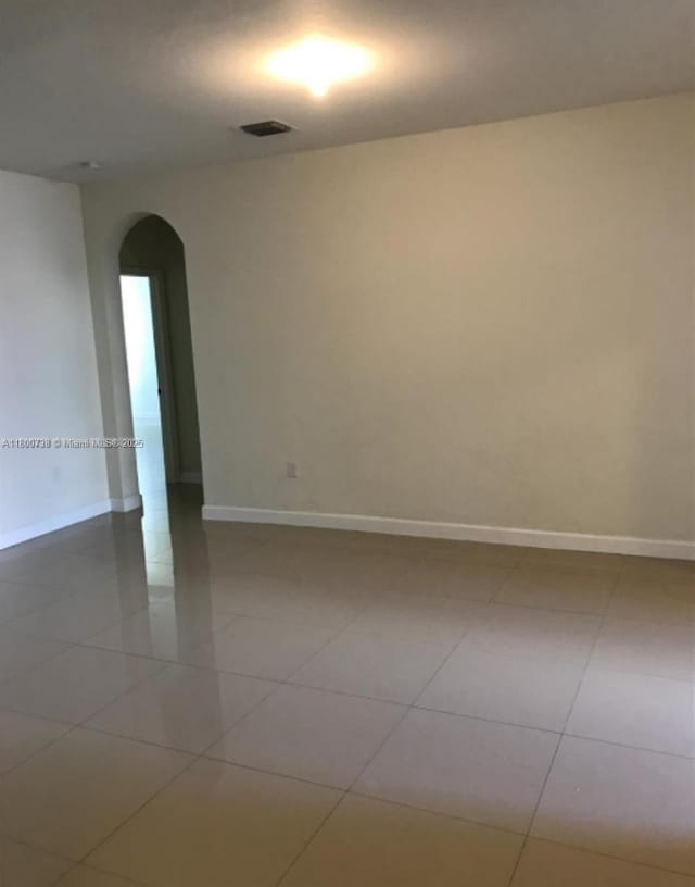 15400 SW 176th Ln, Miami, FL 33187 - unfurnished room with arched walkways, tile patterned floors, and baseboards