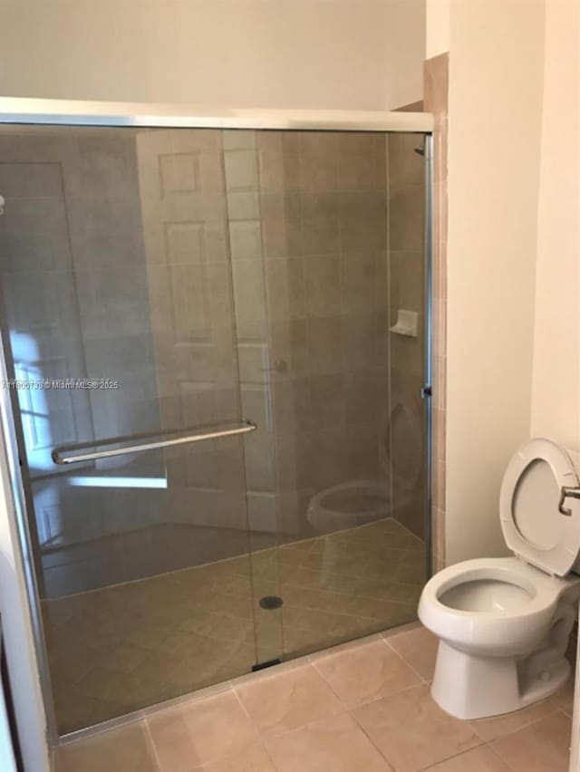 15400 SW 176th Ln, Miami, FL 33187 - bathroom featuring tile patterned floors, toilet, and a stall shower