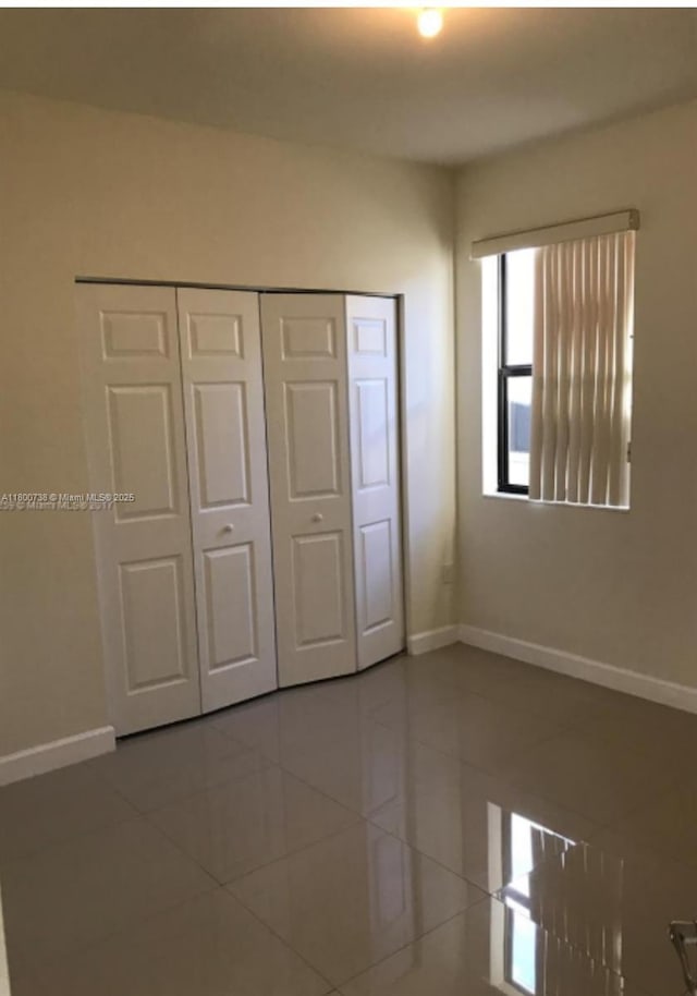 15400 SW 176th Ln, Miami, FL 33187 - unfurnished bedroom with tile patterned floors, baseboards, and a closet