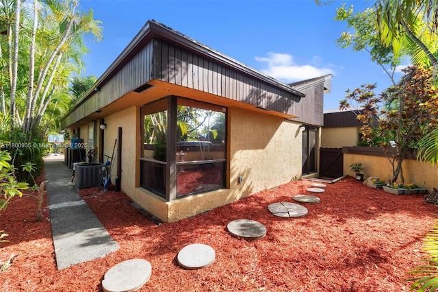 1032 NE 204th Ln Unit B, Miami, FL 33179 - back of house featuring stucco siding, central AC, and a gate