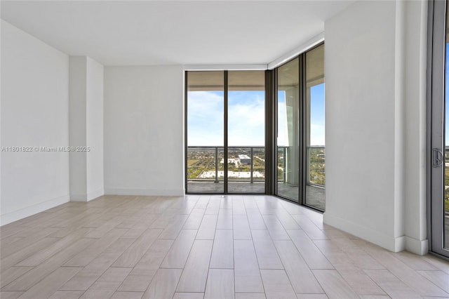 2000 Metropica Way Unit 2504, Sunrise, FL 33323 - unfurnished room featuring a wall of windows, baseboards, and light wood-style flooring