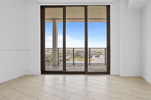 2000 Metropica Way Unit 2504, Sunrise, FL 33323 - tiled spare room with expansive windows, a water view, and baseboards