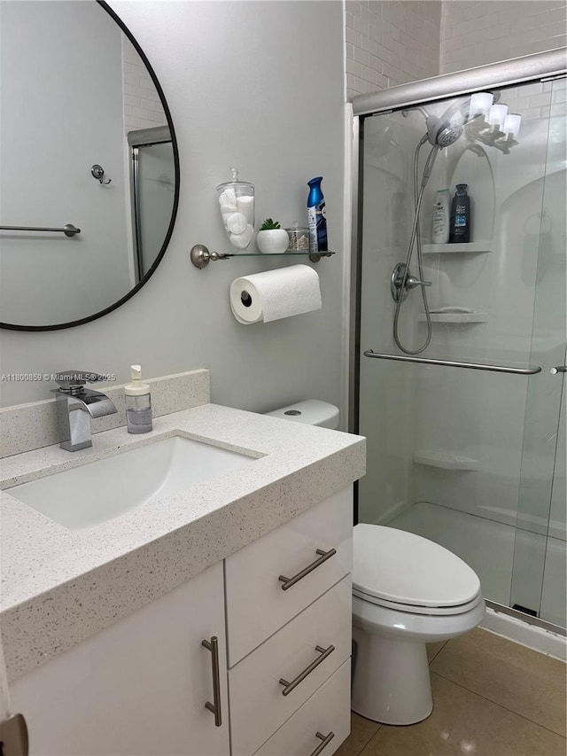 full bathroom featuring a shower stall, vanity, toilet, and tile patterned flooring