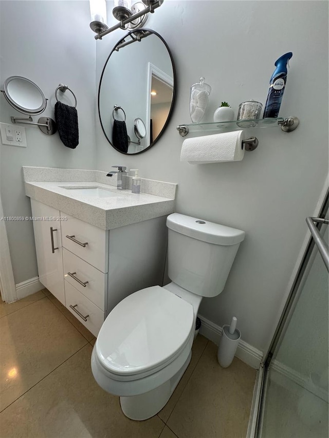 bathroom with toilet, vanity, and baseboards